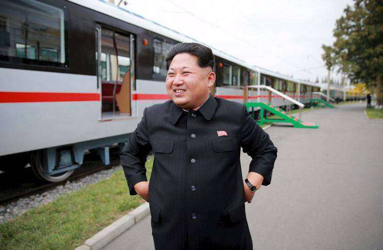 Pemimpin Korea Utara, Kim Jong Un sedang berpose dengan latar belakang kereta