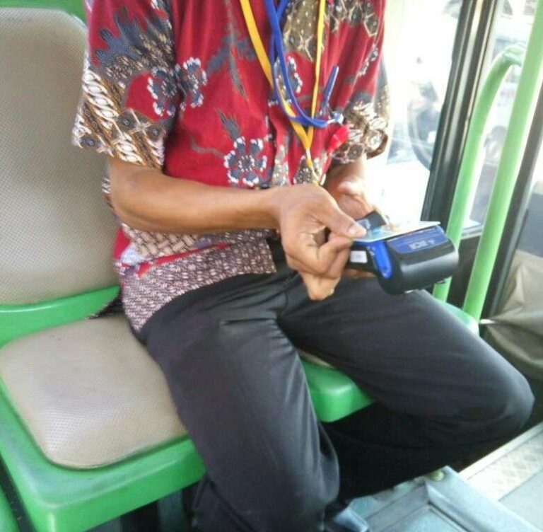 Proses tap-in yang dilakukan di dalam bis feeder. | Foto: Bramantyo