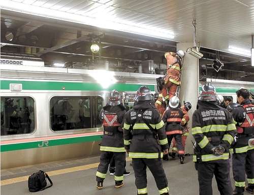 001_size4 Sejumlah petugas pemadam kebakaran yang tengah memeriksa dampak kebakaran pada rangkaian di peron stasiun Sendai. (Kahoku.jp)