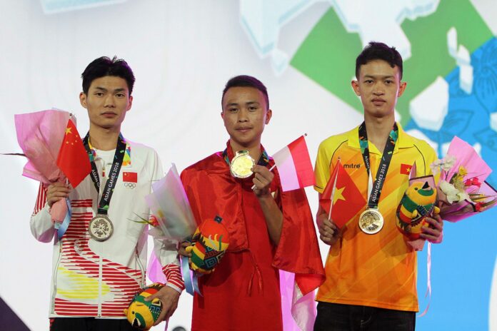 Pemain Indonesia, Sumarandak Ridel alias BenZerRidel (tengah), pemain Cina Huang Chenghui alias Lciop (kiri) dan pemain Vietnam, Huynh Duc Huyi alias Legend (kanan) berfoto saat penyerahan medali nomor Clash Royale eSport Asian Games 2018 di Britama Arena